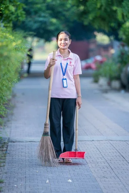 Man cleaning a room with a vacuum cleaner, barefoot in pajamas, ensures tidiness.